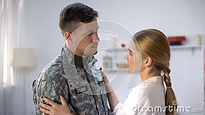 Upset US military man sadly looking at girlfriend, long parting, depression Stock Photo