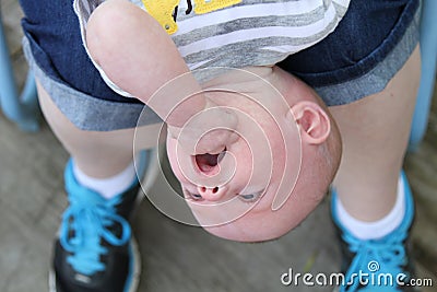 Upside down baby boy and mommy's feet closeup Stock Photo