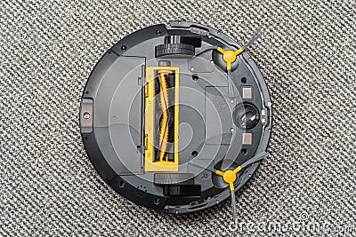 Upside down robot vacuum cleaner on carpet Stock Photo