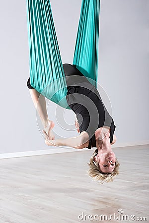 Upside down woman doing aerial yoga back bends Stock Photo