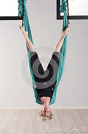 Upside down woman doing aerial yoga head stands Stock Photo
