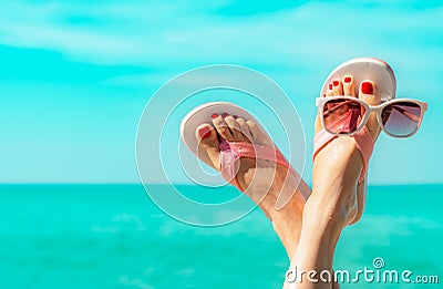 Upside woman feet and red pedicure wearing pink sandals, sunglasses at seaside. Funny and happy fashion young woman relax Stock Photo