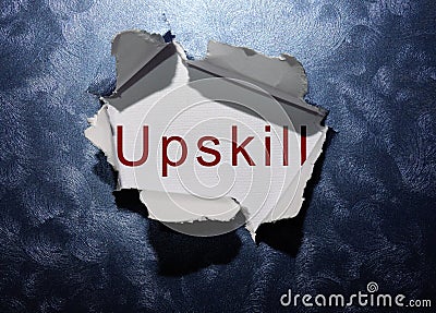 Upskill text revealed in ripped blue paper background Stock Photo