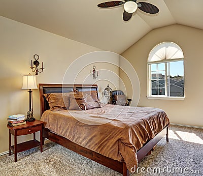 Upstairs bedroom with vaulted ceiling and arch window Stock Photo