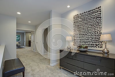 Upstairs landing filled with dark chest of drawers and leather bench. Stock Photo