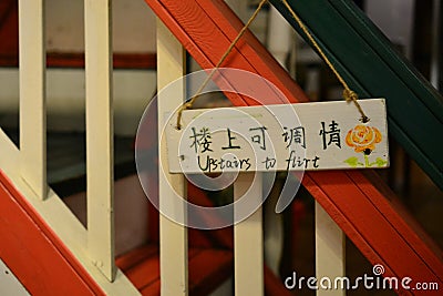 Upstairs to flirt - cute sign at stairs in cafe in Yangshuo, Guangxi, China Editorial Stock Photo