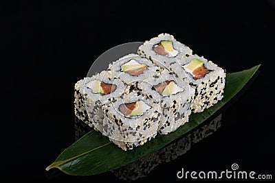 Uramaki maki sushi, two rolls on black background. Philadelphia cheese, tuna, cucumber and sesame Stock Photo