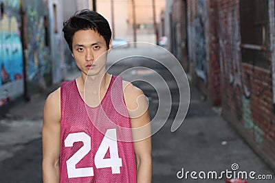 Urban Asian man posing wearing tank top Stock Photo