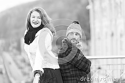 Urban couple on the bridge. Happy couple standing back to back. Men and woman look in one way. Smiling brunet hair woman and happy Stock Photo