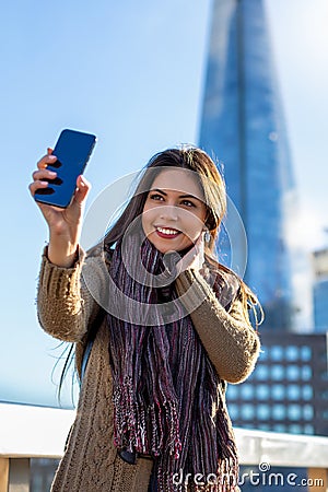 Urban fashionista girl with cellphone in London Stock Photo