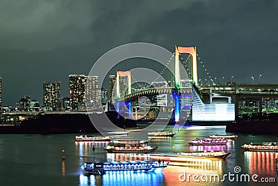 Urban landscape of Tokyo Rainbow bridge with illuminated tourist boats Editorial Stock Photo