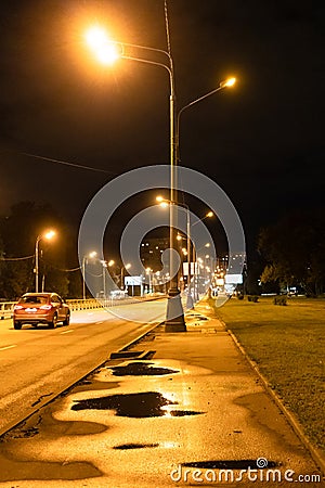 Urban lantern illuminated road after rain in nigh Stock Photo