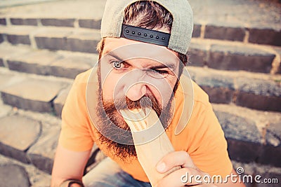 Urban lifestyle nutrition. Junk food. Carefree hipster eat junk food while sit stairs. Guy eating hot dog. Snack for Stock Photo