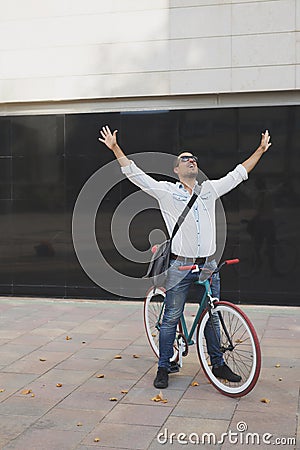 Urban man on a bike with arms rise successful day Stock Photo