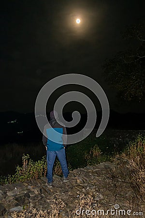 Urban Man Mesmerized by Full Moon over Uttarakhand Himalayas Stock Photo