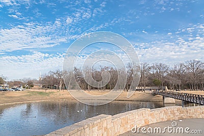 Urban park bare tree, altocumulus cloud, fountain lake in Texas, USA Editorial Stock Photo