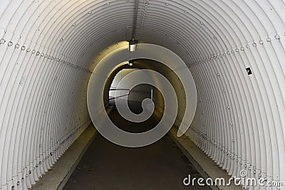 Urban pedestrian subway, underpass or walk-through in the shape of white tunnel with ceiling. Stock Photo