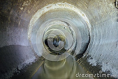 Urban sewage flowing throw round sewer tunnel pipe Stock Photo