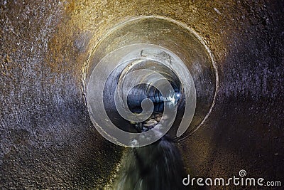 Urban sewage flowing throw round sewer tunnel pipe Stock Photo