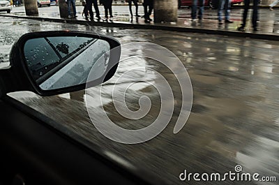 Urban street from inside a moving car, rainy day in a city, people on the sidewalk on a rainy day Stock Photo