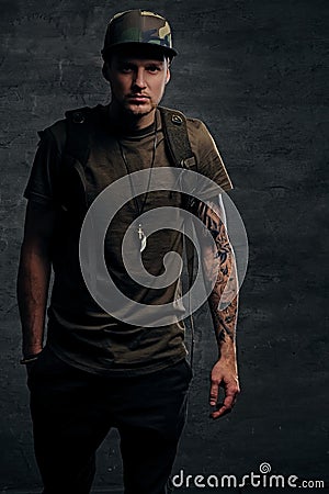 Backpacker in Camo green t shirt and tattoos on arms. Stock Photo