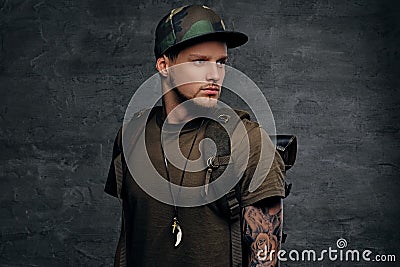 Backpacker in Camo green t shirt and tattoos on arms. Stock Photo