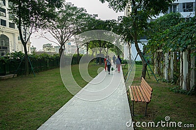 Urban walking road among green trees inside modern apartment building area in big city Editorial Stock Photo