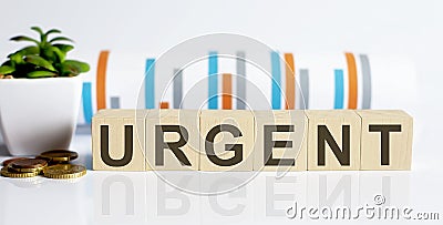 URGENT word letters on wooden blocks with coins. BUSINESS Stock Photo