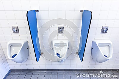 Urinals for men on white wall with blue partitions Stock Photo