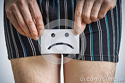 Urinary or prostate problems concept. Young man holds paper with SOS above crotch. Stock Photo