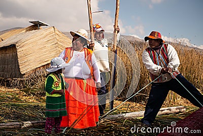 The Uros indigenous family help to unmoor the traditional boat made of totora reeds Editorial Stock Photo