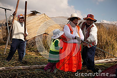 The Uros indigenous family help to unmoor the traditional boat made of totora reeds Editorial Stock Photo