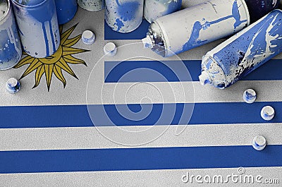 Uruguay flag and few used aerosol spray cans for graffiti painting. Street art culture concept Stock Photo