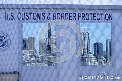 US Customs & Border Protection behind Chain Link Fence with US city reflected in windows Editorial Stock Photo