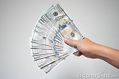 US dollar bills money in hand on white background. Close up businessman hand holding or giving many one hundred dollar banknotes Stock Photo