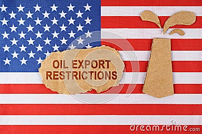 On the US flag there is an oil rig cut out of cardboard and a sign with the inscription - oil export restrictions Stock Photo