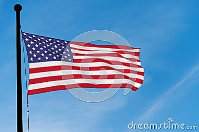 US Flag waving over blue sky Stock Photo