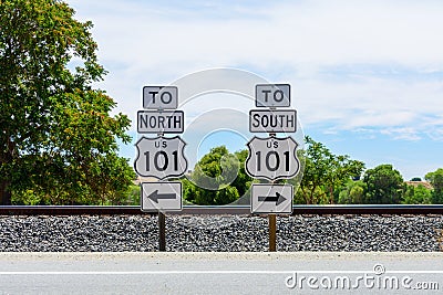 US Highway 101 directional signs. North and South freeway road signs. Background railroad tracks and green trees Stock Photo