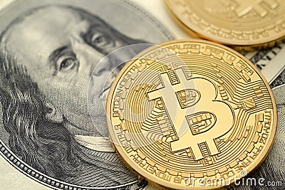 US hundred dollar bills and physical golden bitcoin Stock Photo