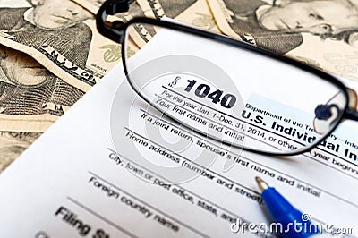 US 1040 individual tax return form, glasses and dollar bills with pen Editorial Stock Photo