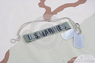 US MARINES branch tape with dog tags on desert camouflage uniform Stock Photo