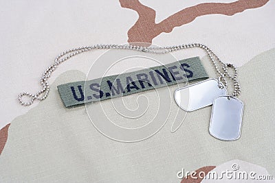 US MARINES branch tape with dog tags on desert camouflage uniform Stock Photo