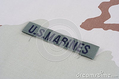 US MARINES branch tape with dog tags on desert camouflage uniform Stock Photo