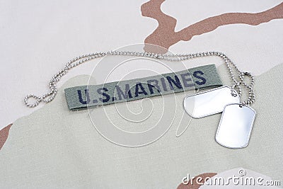 US MARINES branch tape with dog tags on desert camouflage uniform Stock Photo