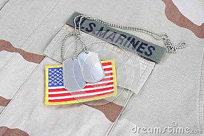 US MARINES branch tape with dog tags and flag patch on desert camouflage uniform Editorial Stock Photo