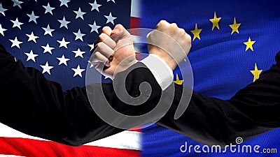 US vs EU confrontation, countries disagreement, fists on flag background Stock Photo