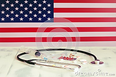 USA flag on the background of tablets, stethoscope and syringe on the table. US flag and medical supplies Stock Photo