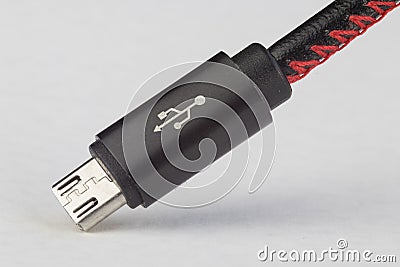 USB plug jack cable with symbol, black cable and white background. Stock Photo