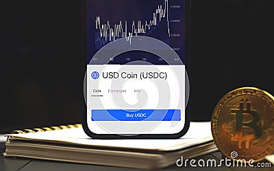 USDC USD Coin Cryptocurrency business background, crypto graphs on the screen of mobile phone Editorial Stock Photo