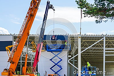 Use of modern telescopic crane and scissor lifts in sandwich panel wall mounting Stock Photo